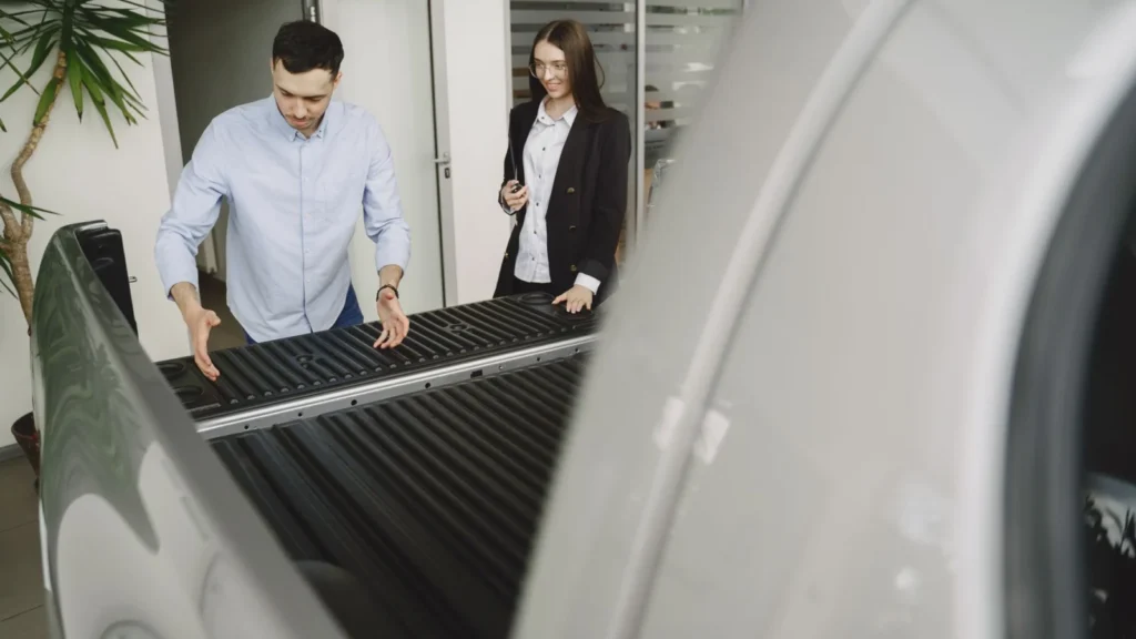 Salesman and client inspecting a pickup truck in a car dealership, discussing features — SSK Mechanics guide to What Is a Pre-Purchase Vehicle Inspection and Do You Need One