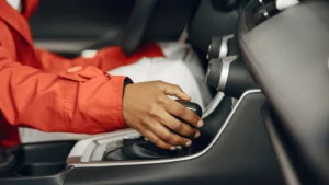 Close-up view of a person shifting gears in a car interior, illustrating driving expertise — SSK Mechanics guide to Test Driving a Used Car: What to Look and Listen For