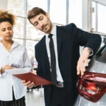 Businessman and customer discussing car purchase inside modern showroom — SSK Mechanics guide to Understanding a Car's Service History and Why It Matters
