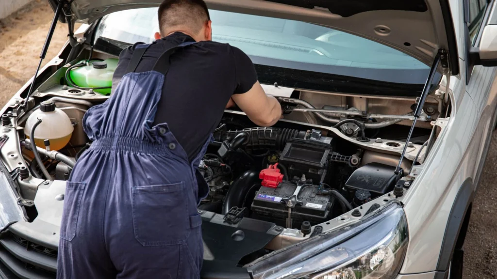 Close-up of mechanic repairing a car engine. Outdoor setting during the day — SSK Mechanics guide to Mobile Mechanic Reviews: How to Check if a Company Is…