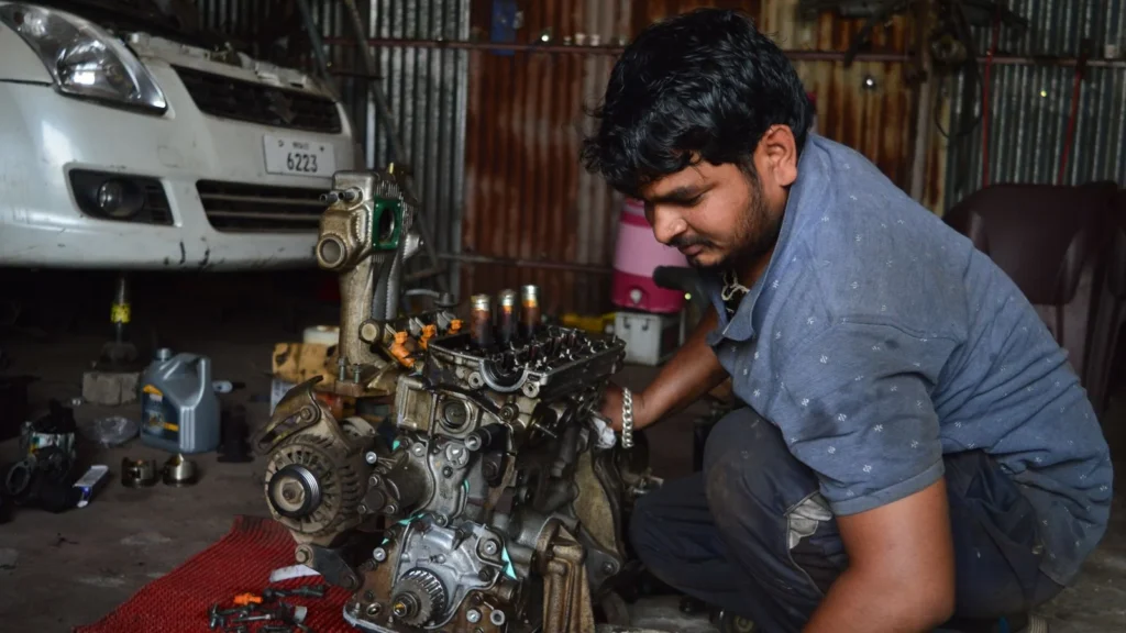 A mechanic works on an engine in a garage in India, showcasing auto repair skills — SSK Mechanics guide to Managing Multiple Vehicles: Scheduling Servicing Across a…