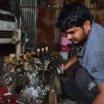 A mechanic works on an engine in a garage in India, showcasing auto repair skills — SSK Mechanics guide to Managing Multiple Vehicles: Scheduling Servicing Across a…