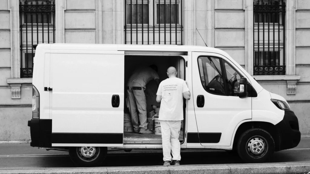 Monochrome image of a delivery van with workers, showcasing urban logistics — SSK Mechanics guide to Emergency Breakdown Cover: What Working Van Owners Should…