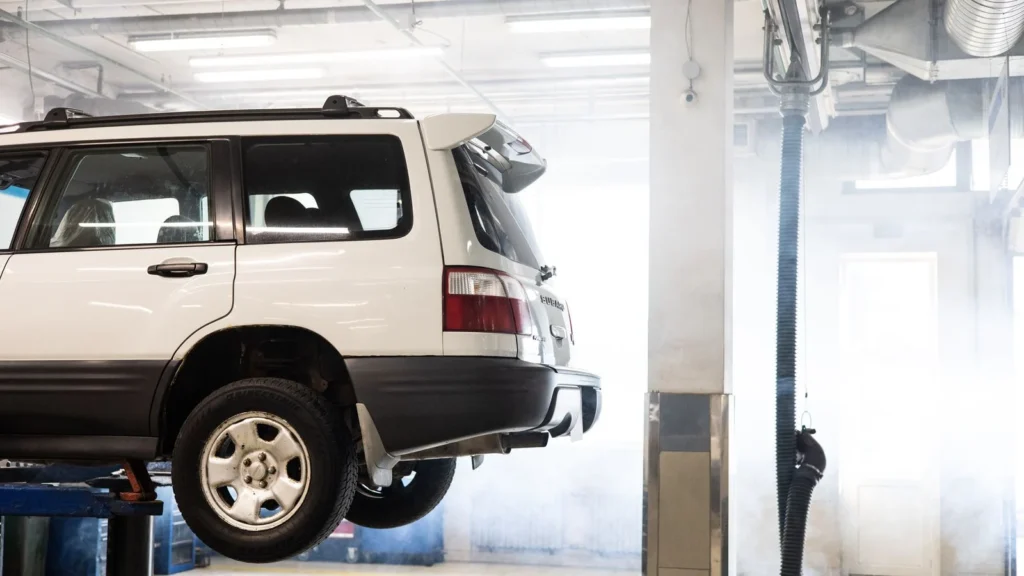A white SUV is elevated on a lift inside an auto repair shop for maintenance — SSK Mechanics guide to Van MOT Preparation: A Checklist for Business Owners