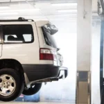 A white SUV is elevated on a lift inside an auto repair shop for maintenance — SSK Mechanics guide to Van MOT Preparation: A Checklist for Business Owners