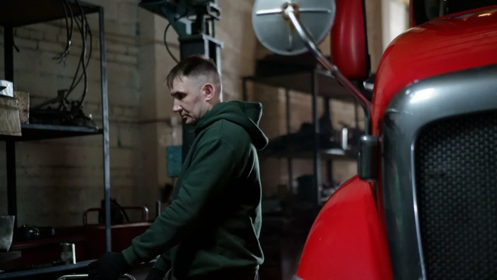 Mechanic in garage inspecting a red truck to ensure optimal performance — SSK Mechanics guide to Diagnostics and Fault Finding for Commercial Vans: Why It Matters