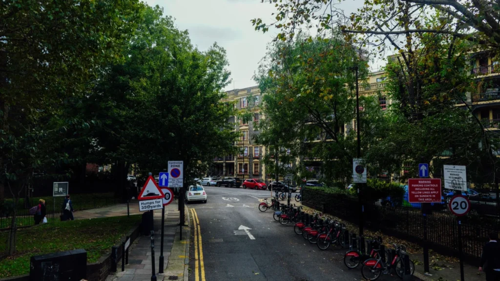 Scenic urban street view with parked bicycles and lush trees on a calm autumn day — SSK Mechanics guide to Clean Air Zones Explained: What UK Drivers Need to Know