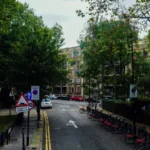 Scenic urban street view with parked bicycles and lush trees on a calm autumn day — SSK Mechanics guide to Clean Air Zones Explained: What UK Drivers Need to Know