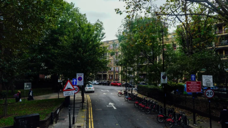 Scenic urban street view with parked bicycles and lush trees on a calm autumn day — SSK Mechanics guide to Clean Air Zones Explained: What UK Drivers Need to Know