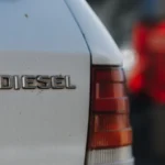 Detailed view of a diesel car badge with blurred background, captured in Prague — SSK Mechanics guide to Short Journeys and Your DPF: Why Stop-Start Driving Causes…