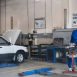 Mechanic in blue coveralls working on an engine in a modern auto repair workshop — SSK Mechanics guide to Why Brake Work Isn't a Safe DIY Job for Most Drivers