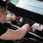 A mechanic working on car engine repairs inside a workshop setting — SSK Mechanics guide to Whining Noise While Driving: What Causes It