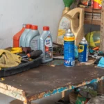 A cluttered workbench in an automobile garage with tools, oil cans, and maintenance products — SSK Mechanics guide to AA Mobile Servicing vs SSK Mechanics: Comparing Cost, Speed…