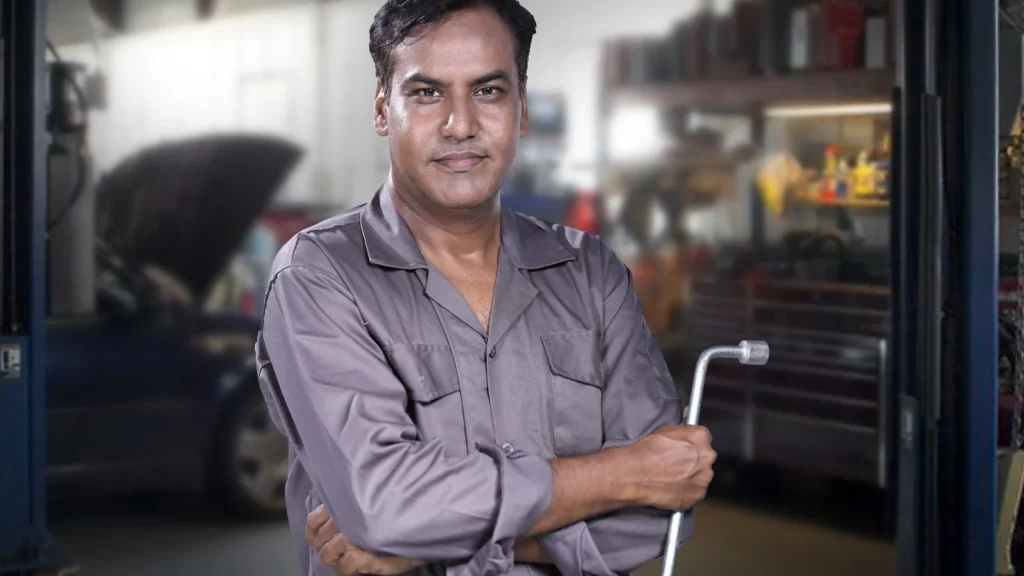 Portrait of a skilled mechanic holding a lug wrench in a Karachi auto repair shop — SSK Mechanics guide to ClickMechanic Quotes vs SSK Mechanics: How the Pricing Models…