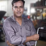 Portrait of a skilled mechanic holding a lug wrench in a Karachi auto repair shop — SSK Mechanics guide to ClickMechanic Quotes vs SSK Mechanics: How the Pricing Models…
