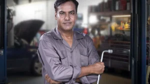 Portrait of a skilled mechanic holding a lug wrench in a Karachi auto repair shop — SSK Mechanics guide to ClickMechanic Quotes vs SSK Mechanics: How the Pricing Models…
