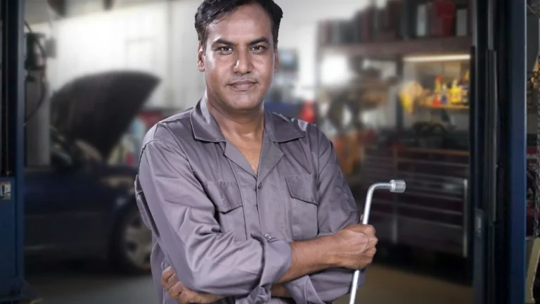 Portrait of a skilled mechanic holding a lug wrench in a Karachi auto repair shop — SSK Mechanics guide to ClickMechanic Quotes vs SSK Mechanics: How the Pricing Models…