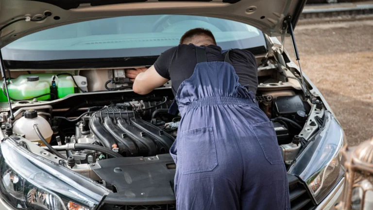 Mechanic carrying out an under-bonnet repair outdoors — SSK Mechanics comparison of mobile mechanics and national service centres