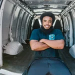 African American man with a beard sitting and smiling inside an empty van, showcasing relaxation… — SSK Mechanics guide to AA Business Breakdown Cover vs Scheduled Mobile Fleet Maintenance