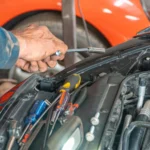 Mechanic performing maintenance on a car engine in a garage setting, using various tools — SSK Mechanics guide to ClickMechanic Leeds vs SSK Mechanics: Coverage and Response…