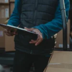 Courier uses clipboard to manage parcel delivery from van load — SSK Mechanics guide to National Fleet Contracts vs a Local Mobile Mechanic: What…