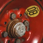 Detailed view of a rusty red spare car wheel with an '80 KM/H' max speed warning label — SSK Mechanics guide to Kwik Fit MOT Advisories vs a Second Opinion: Why It's Worth…