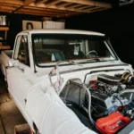A vintage pickup truck undergoing engine repairs in a well-equipped home garage — SSK Mechanics guide to AA Vehicle Inspection vs a Mobile Mechanic Pre-Purchase…