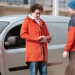Two delivery men in bright jackets using a digital tablet beside a van outdoors — SSK Mechanics guide to DIY Car Repair vs Booking ClickMechanic or a Local Mobile…