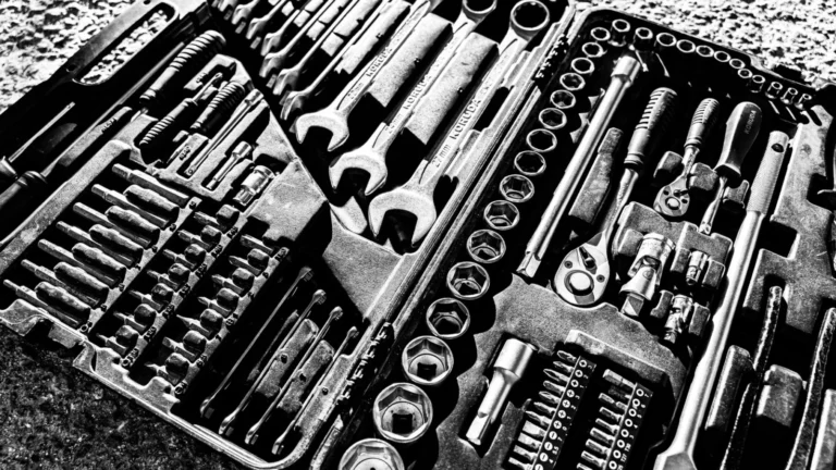 Close-up black and white photo of a complete wrench and socket tool set within a toolbox — SSK Mechanics guide to Halfords DIY Parts Counter vs Professional Fitting: What's…